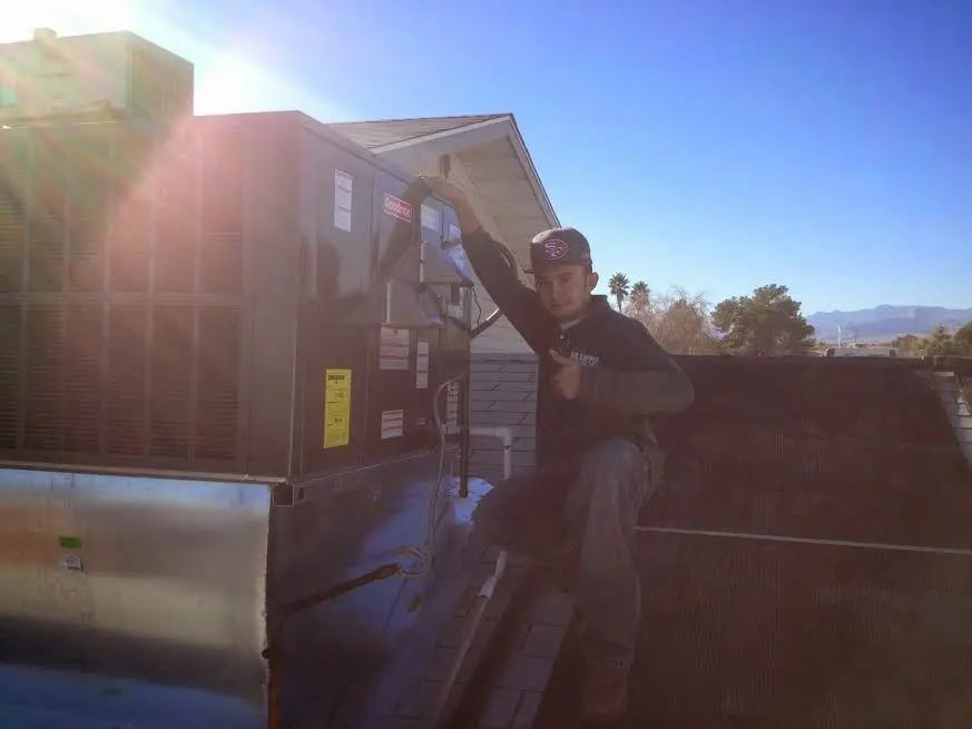 HVAC technician performing AC Tune-Up on a rooftop unit in Cudahy